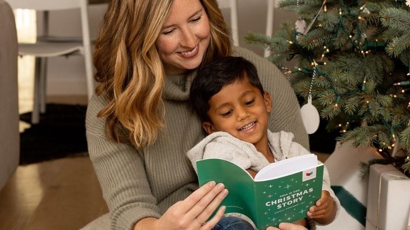 Woman reading a Christmas story to a child.
